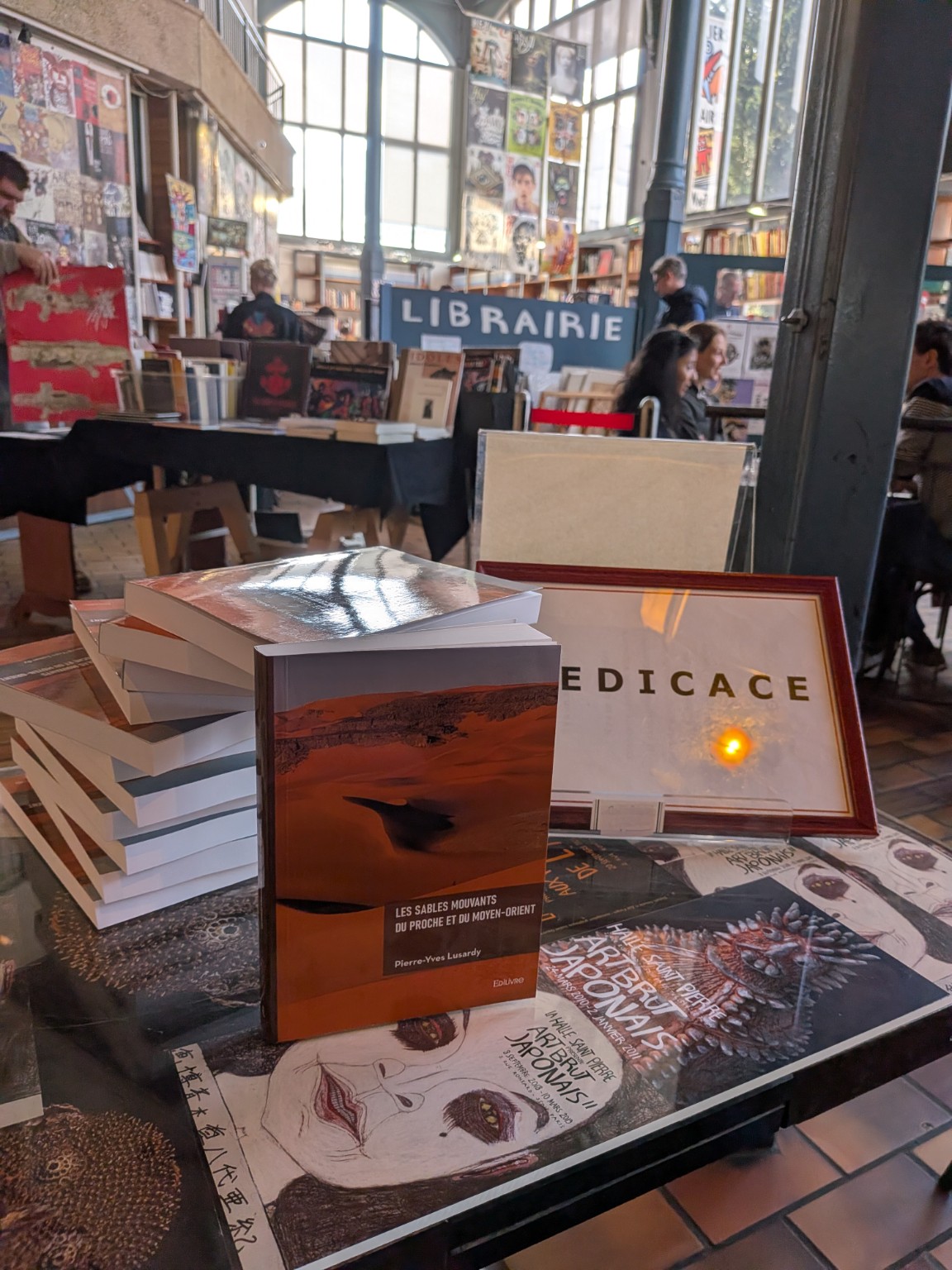 Le livre de Pierre-Yves Lusardy présenté sur une table de dédicaces dans une librairie, avec une pile d’exemplaires à ses côtés.